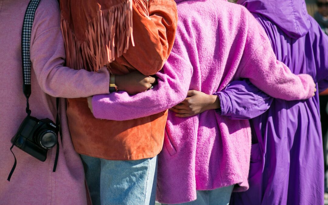 four person holding each others waist at daytime