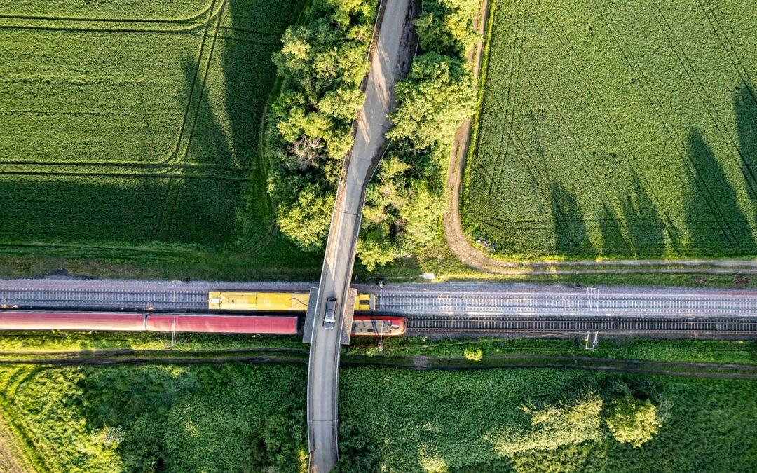 an aerial view of a train crossing a road