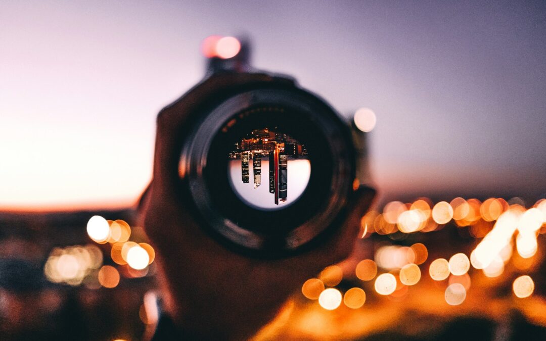 shallow focus photography of person holding camera lens