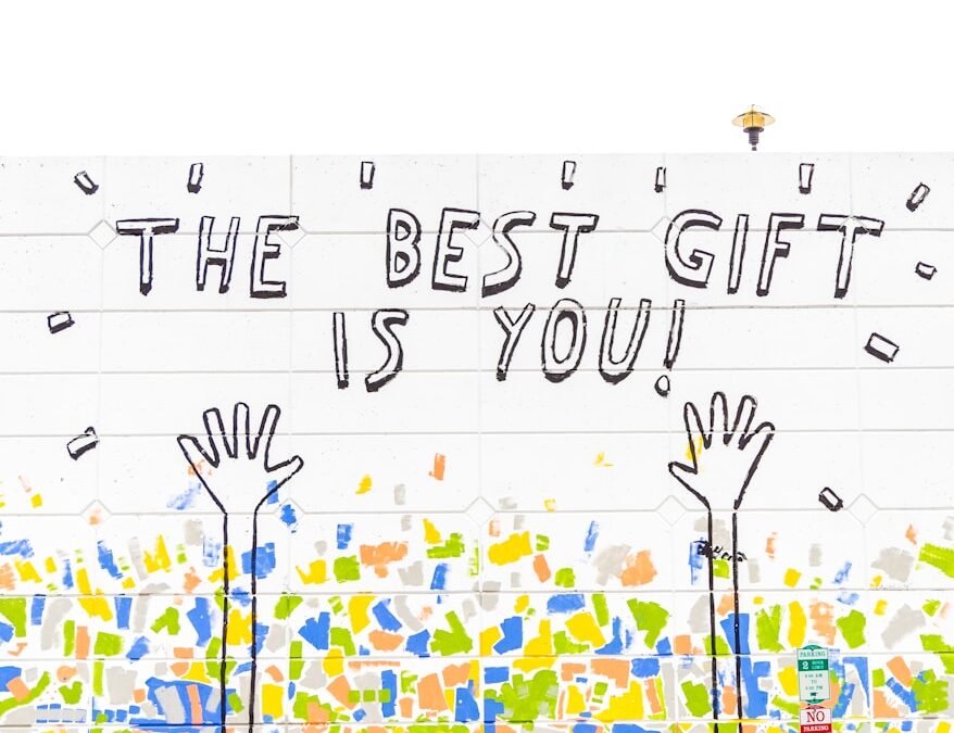 woman walking beside wall with the best gift is you graffiti