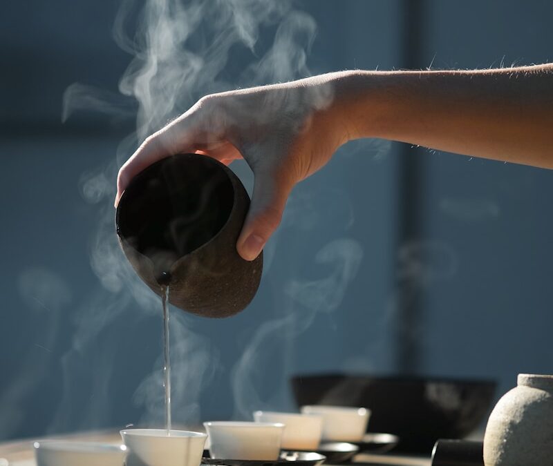 person pouring hot water on white cup