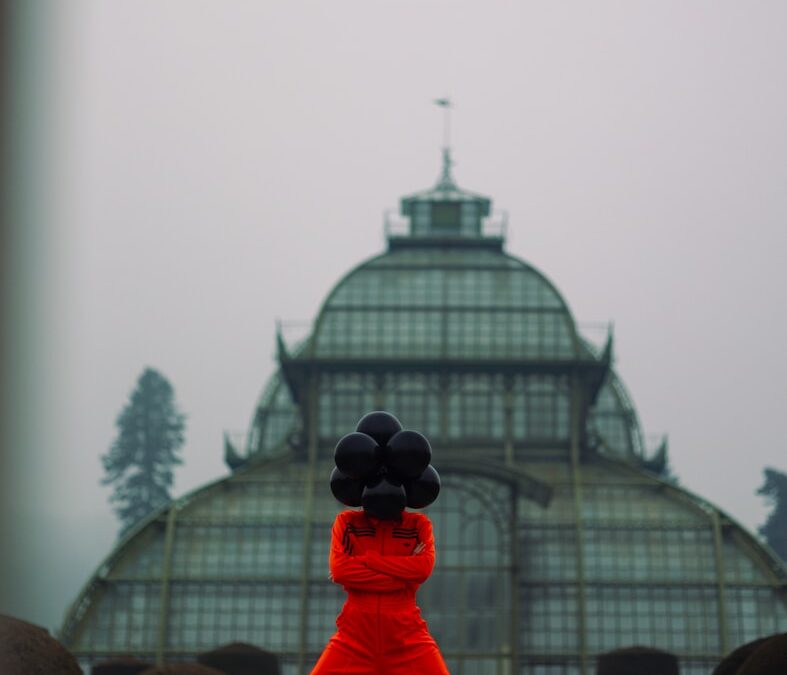 A person in a red outfit is holding a black object