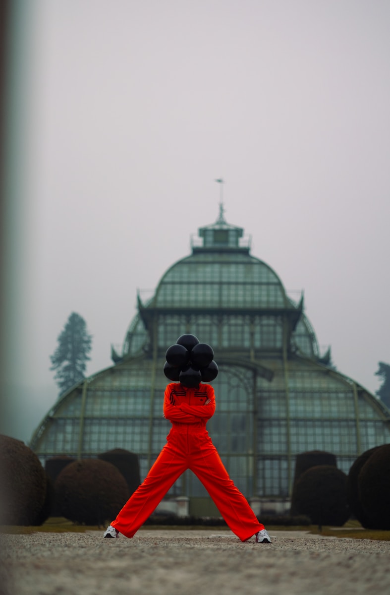 A person in a red outfit is holding a black object